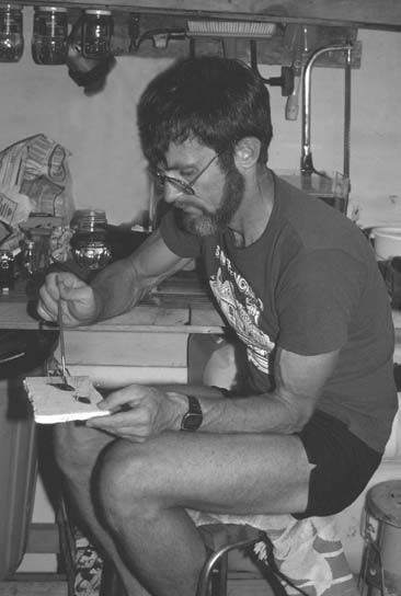 ANGFA Patron Dr Jerry Allen “at work”. Hopefully the tools displayed in the background are not his “tools of trade”